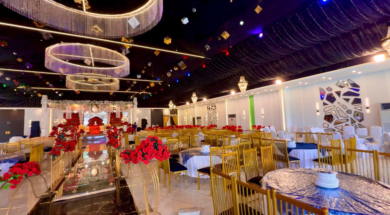 Dining area inside Gudar Wedding Hall with floral table arrangements